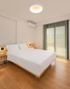 a large white bed in a room with wooden floors at ASTRA IN CITY in Ioannina
