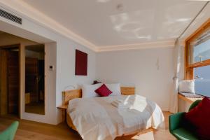 a white bedroom with a bed and a window at Polreich Bed&Breakfast in Hallstatt