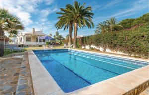a swimming pool with palm trees and a house at Stunning Home In El Campello With Wifi in El Campello