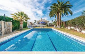 een zwembad met palmbomen en een huis bij Gorgeous Home In El Campello With Outdoor Swimming Pool in El Campello