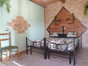 een slaapkamer met een bed en een stoel bij Stanza Del Viggiatore in Santadi