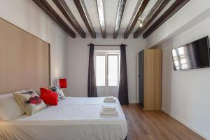 sypialnia z łóżkiem i telewizorem na ścianie w obiekcie TACITA Family Home by Cadiz4Rentals w Kadyksie
