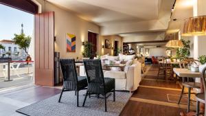 a living room with a couch and a table and chairs at Pousada Vila Real Santo Antonio in Vila Real de Santo António