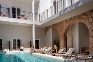 a group of people sitting in a swimming pool at Pousada Vila Real Santo Antonio in Vila Real de Santo António