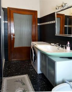 a bathroom with a washing machine and a sink at Affittacamere La Foresta di Sopra in Barga