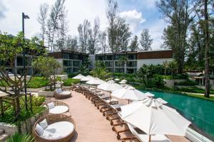 a resort with a pool with chairs and umbrellas at InterContinental Phuket Resort by IHG in Kamala Beach
