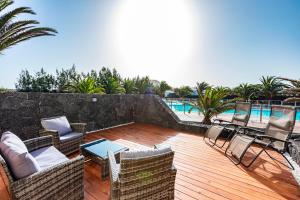 Un patio con sillas y una mesa y una piscina. en Casa Sissy, en Playa Blanca