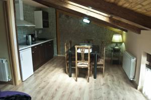 a kitchen with a table and chairs in a room at La casa del rebote in Acedo