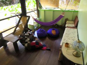 a room with a hammock and a chair and a table at Pangkor Guesthouse SPK in Pangkor