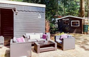 a patio with two couches and a table and a shed at Chalet 115 in Hattemerbroek