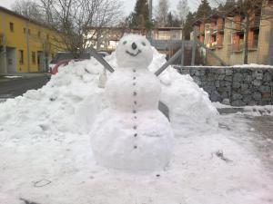 a snowman standing in a pile of snow at Apartmány Doky Holiday in Lipno nad Vltavou