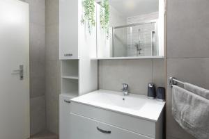 biała łazienka z umywalką i lustrem w obiekcie Sea Point Villa Ivan w mieście Kornić +37 zdjęć