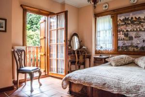 um quarto com uma cama, uma cadeira e janelas em Viraggas Traditional hotel em Vrástama