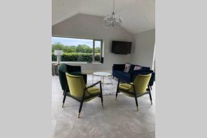 a living room with chairs and a table at Ballyheifer House - a beautiful 5 bedroom home. in Magherafelt