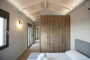 塞沃塔的住宿－Théa boutique villas sivota I，一间卧室配有一张床和一个木制橱柜