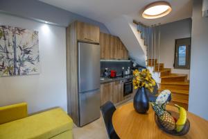 a kitchen with a dining room table with a refrigerator at Théa boutique villas sivota I in Sivota