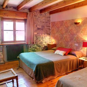 a bedroom with a bed and a brick wall at Casa Anhelo El Candíl in Puebla de Lillo