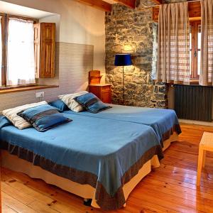 a bedroom with a large bed with blue pillows at Casa Anhelo El Candíl in Puebla de Lillo