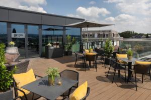 a patio area with tables, chairs and umbrellas at INNSiDE by Meliá Aachen in Aachen