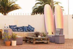 a patio with a couch and two chairs and a table at Hospedium Hostel República Surf House in Ericeira
