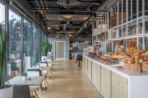 a restaurant with tables and chairs and windows at INNSiDE by Meliá Aachen in Aachen
