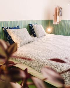 a bedroom with a bed with pillows and a plant at Hospedium Hostel República Surf House in Ericeira