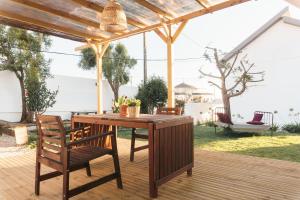 a wooden table and chairs on a wooden deck at Hospedium Hostel República Surf House in Ericeira