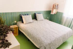 a bedroom with a bed and a green wall at Hospedium Hostel República Surf House in Ericeira