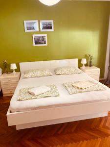 a bedroom with a white bed with green walls at Villa Chiara in Vodice