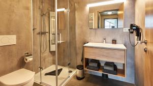 ein Bad mit einem Waschbecken, einer Dusche und einem WC in der Unterkunft UplandParcs Winterberg in Winterberg + 35 Fotos