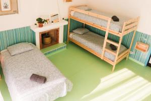 a room with two bunk beds and a fireplace at Hospedium Hostel República Surf House in Ericeira