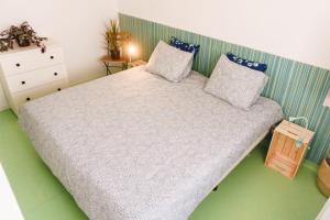 a bedroom with a large bed with blue pillows at Hospedium Hostel República Surf House in Ericeira