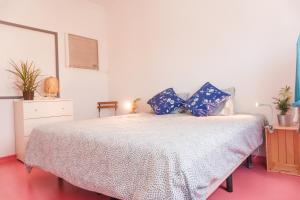 a bedroom with a bed with blue pillows on it at Hospedium Hostel República Surf House in Ericeira
