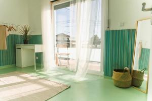a living room with a large window and a table at Hospedium Hostel República Surf House in Ericeira