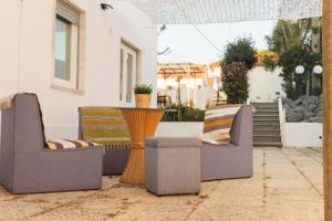 two chairs and a table on a patio at Hospedium Hostel República Surf House in Ericeira