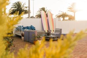a living room with two surfboards and a couch at Hospedium Hostel República Surf House in Ericeira