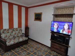 UN RIFUGIO DEL BORGO MEDIEVALE/MEDIEVAL VILLAGE في Gessopalena: غرفة معيشة مع تلفزيون بشاشة مسطحة وكرسي