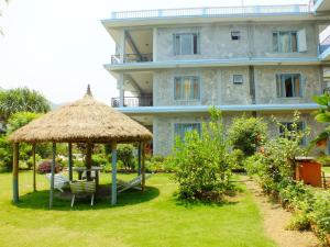 un gran edificio con un patio con sillas y un cenador en Hotel Greenland, en Pokhara 35 fotos más