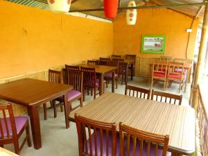 Un comedor con mesas y sillas de madera. en Hotel Greenland, en Pokhara