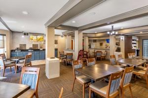 um restaurante com mesas e cadeiras de madeira e uma cozinha em Comfort Suites Denver Tech Center em Centennial