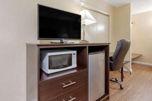 Habitación con escritorio, TV y silla. en Econo Lodge Woodstock - Shenandoah Valley I-81, en Woodstock