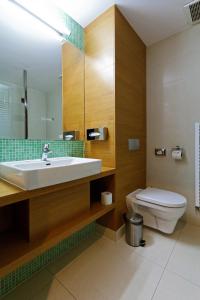 W łazience znajduje się umywalka, toaleta i lustro. w obiekcie IMPIQ Hotel w mieście Trnava