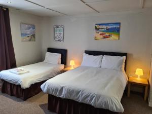 a hotel room with two beds and two lamps at Royal Albion Walton in Walton-on-the-Naze