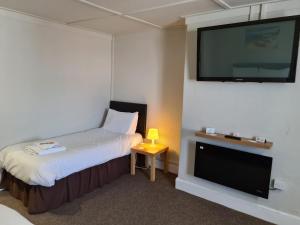 a hotel room with a bed and a flat screen tv at Royal Albion Walton in Walton-on-the-Naze