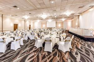 un salón de banquetes con mesas y sillas blancas en Quality Inn & Suites, en Richfield