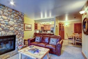 a living room with a couch and a stone fireplace at Empire Coalition #106 in Park City