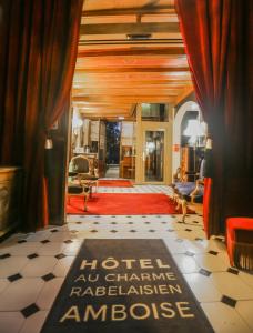 - une entrée avec des rideaux rouges et un tapis rouge dans l'établissement Hotel Spa - Au Charme Rabelaisien, à Amboise