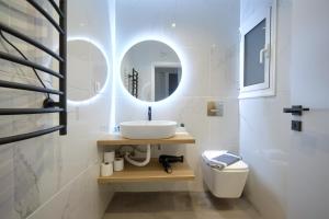 uma casa de banho com um lavatório, um WC e um espelho. em Majestic Flat with Huge Terrace in the City Center em Atenas