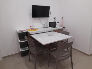 kuchnia ze stołem z komputerem i krzesłami w obiekcie Ortigia spartan house 3 w Syrakuzach +10 zdjęć
