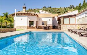 una piscina frente a una casa en Nice Home In Cmpeta With 4 Bedrooms, Wifi And Outdoor Swimming Pool, en Acebuchal